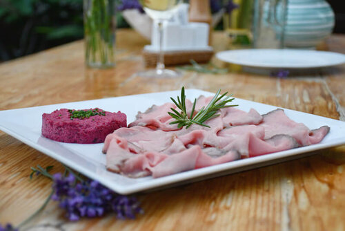 Teller mit aufgeschnittenem Fleisch und Garnierung